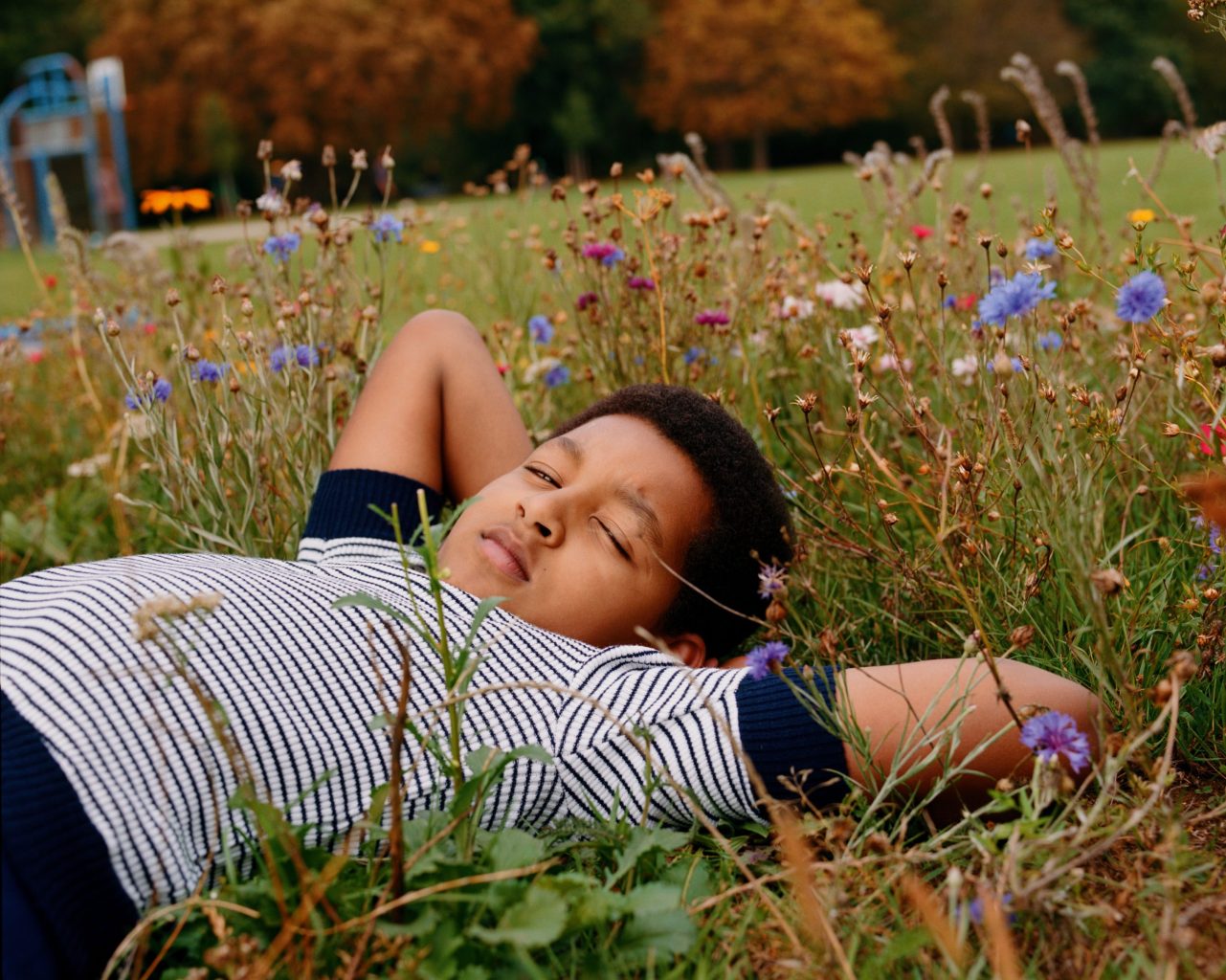 Boy lying in wildflower meadow