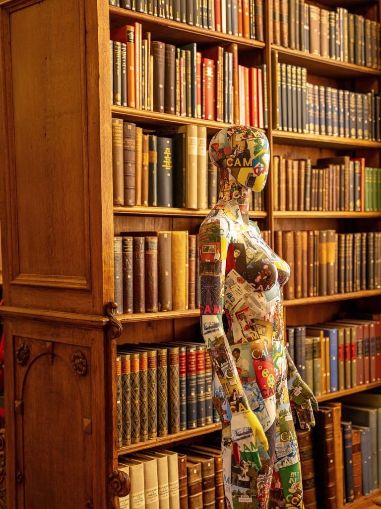 Mannequin covered in CAM magazine covers standing in library