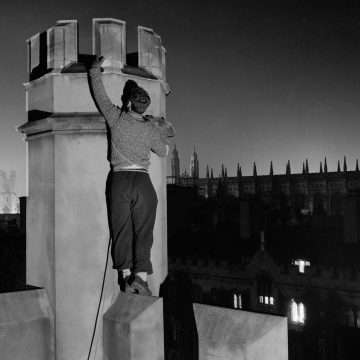 A student night climbing on the outside of one of the historic buildings at Cambridge University