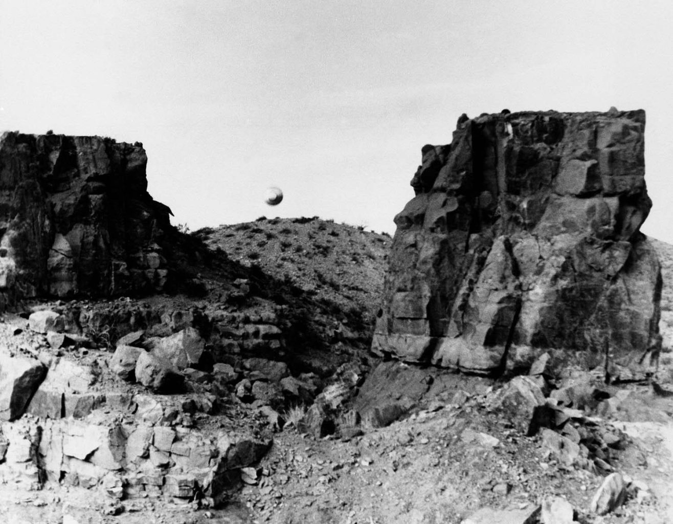 UFO hovering over rocky landscape