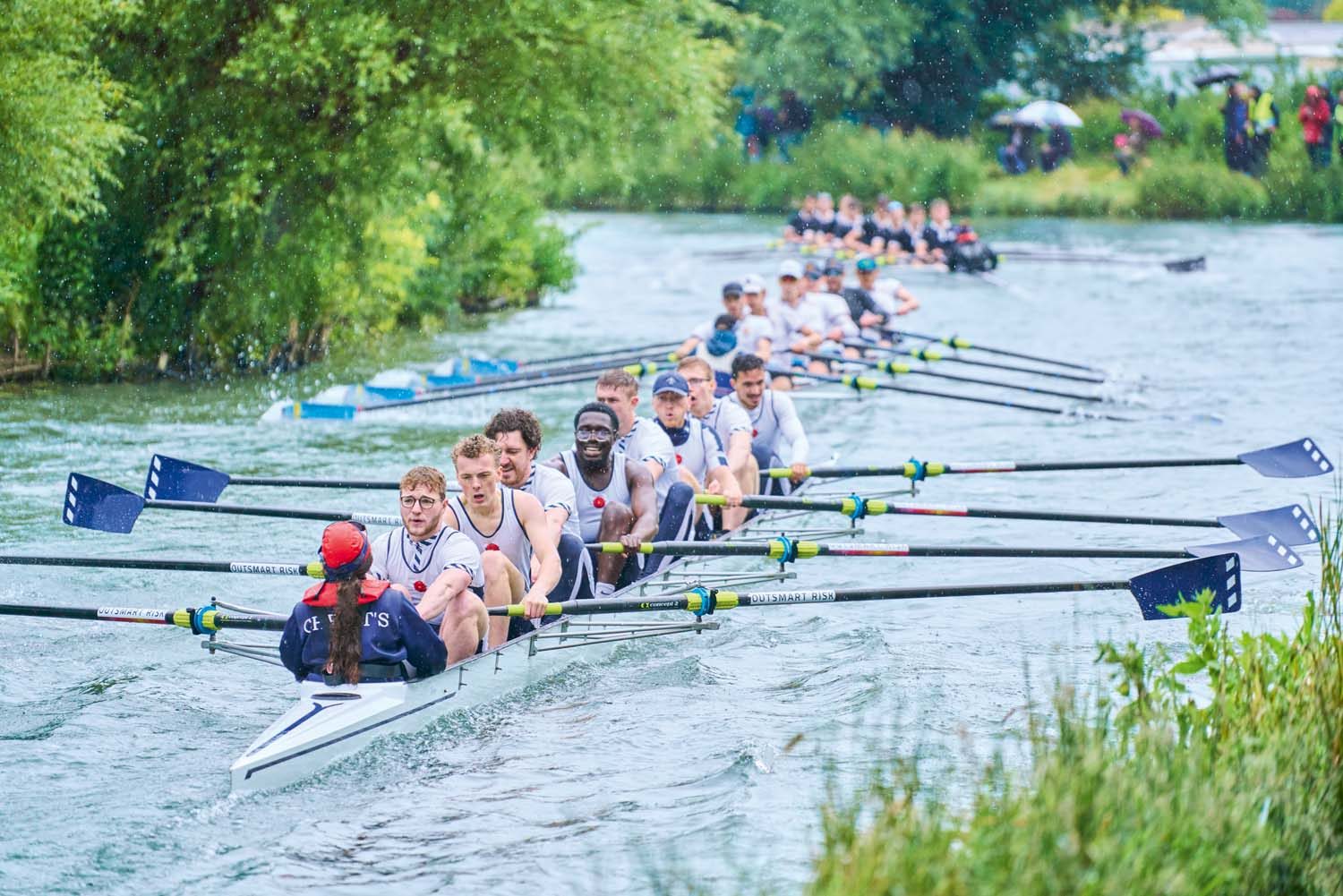 Three boats with students in rowing on the Cam river.